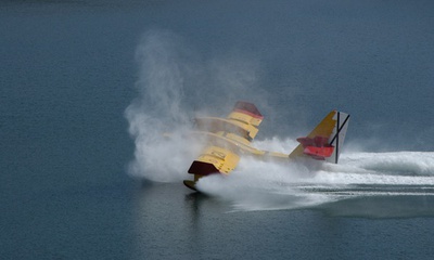Un Canadair mete reversa en ambos motores tras detenerse sobre la superficie del agua