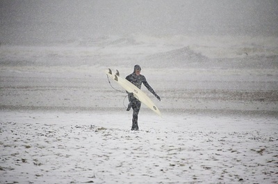 Un surfista se dirige al agua en algún lugar de Dinamarca